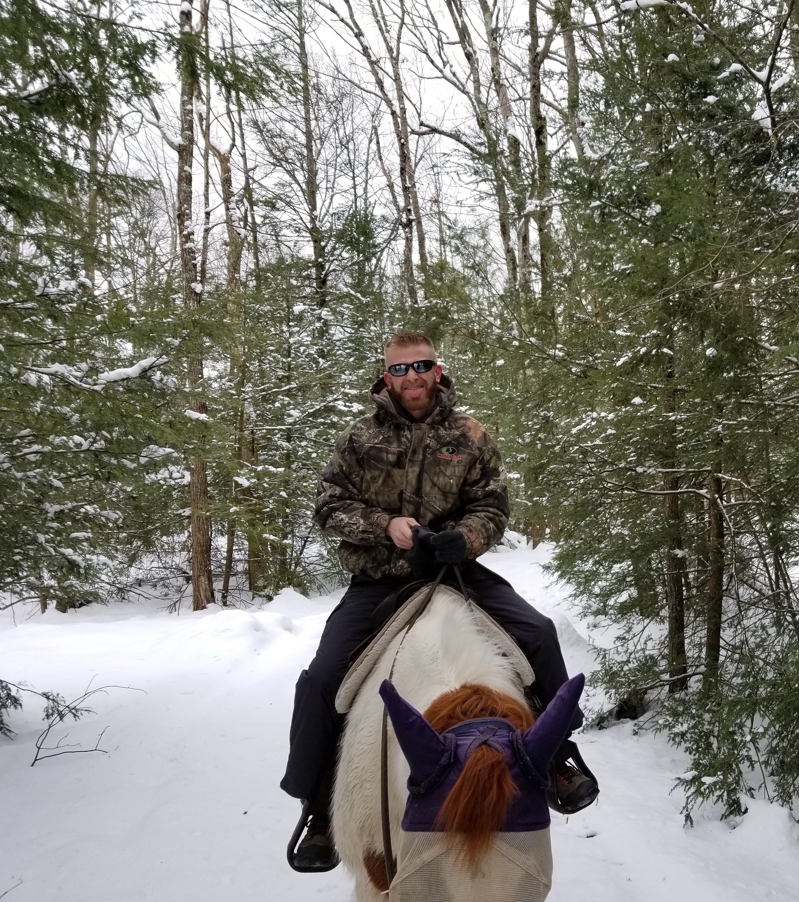 A man horseback riding in the winter.