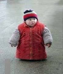 A child bundled up in a huge coat