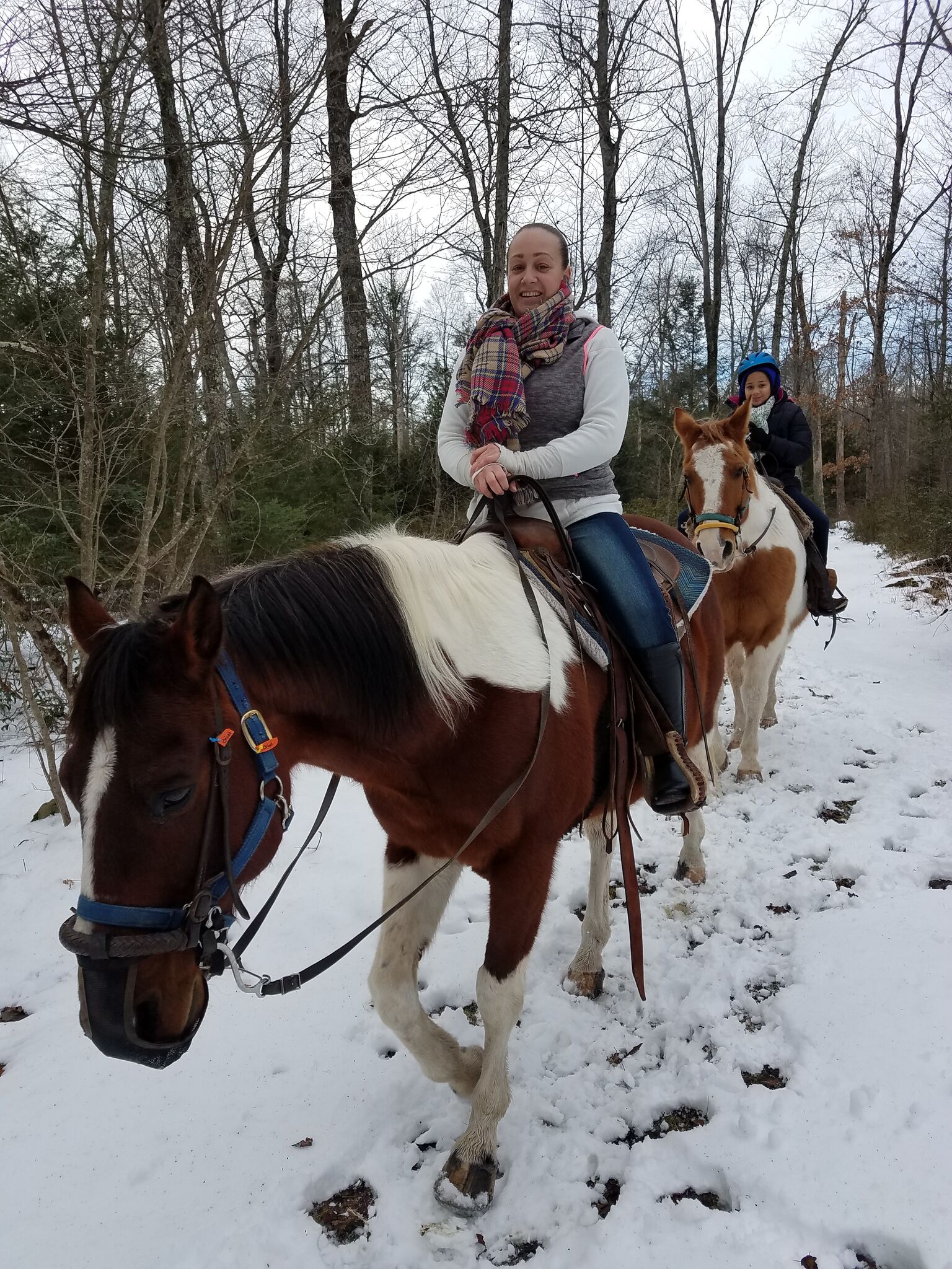 A woman horseback riding in the snow.