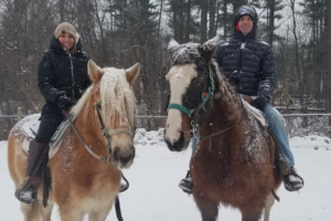Couple on Winter Horseback Ride in the Snow