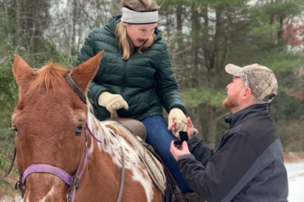 Man Proposing to Woman while She Is Sitting on Brown Horse in the Winter