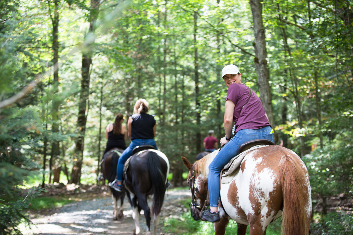 horseback rider smiling on a trail ride in the poconos