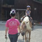 Kid Wearing Purple Helmet on Pony at Mountain Creek Riding Stable