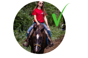 girl on horse in red t-shirt and jeans with green check mark next to image
