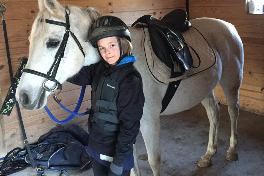 Girl Next to White Horse in Stable - Horseback Riding for Kids